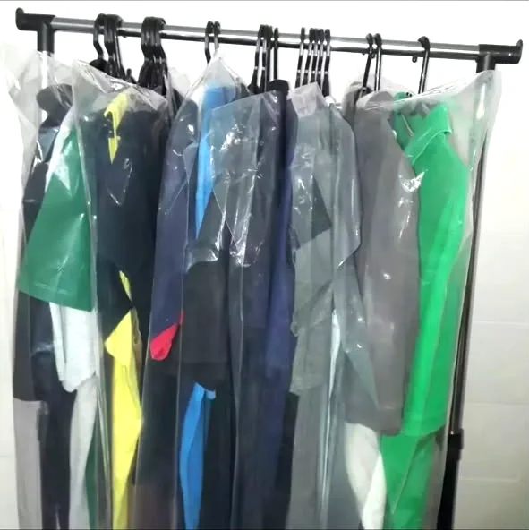 Camisas e calças sociais passadas e protegidas em capas, penduradas na arara da lavanderia