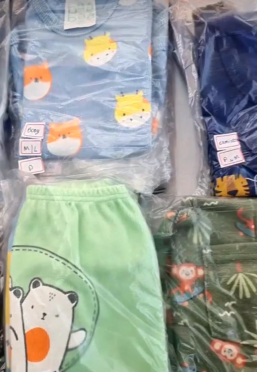 Roupas infantis dobradas e embaladas, com etiquetas separando os tamanhos
